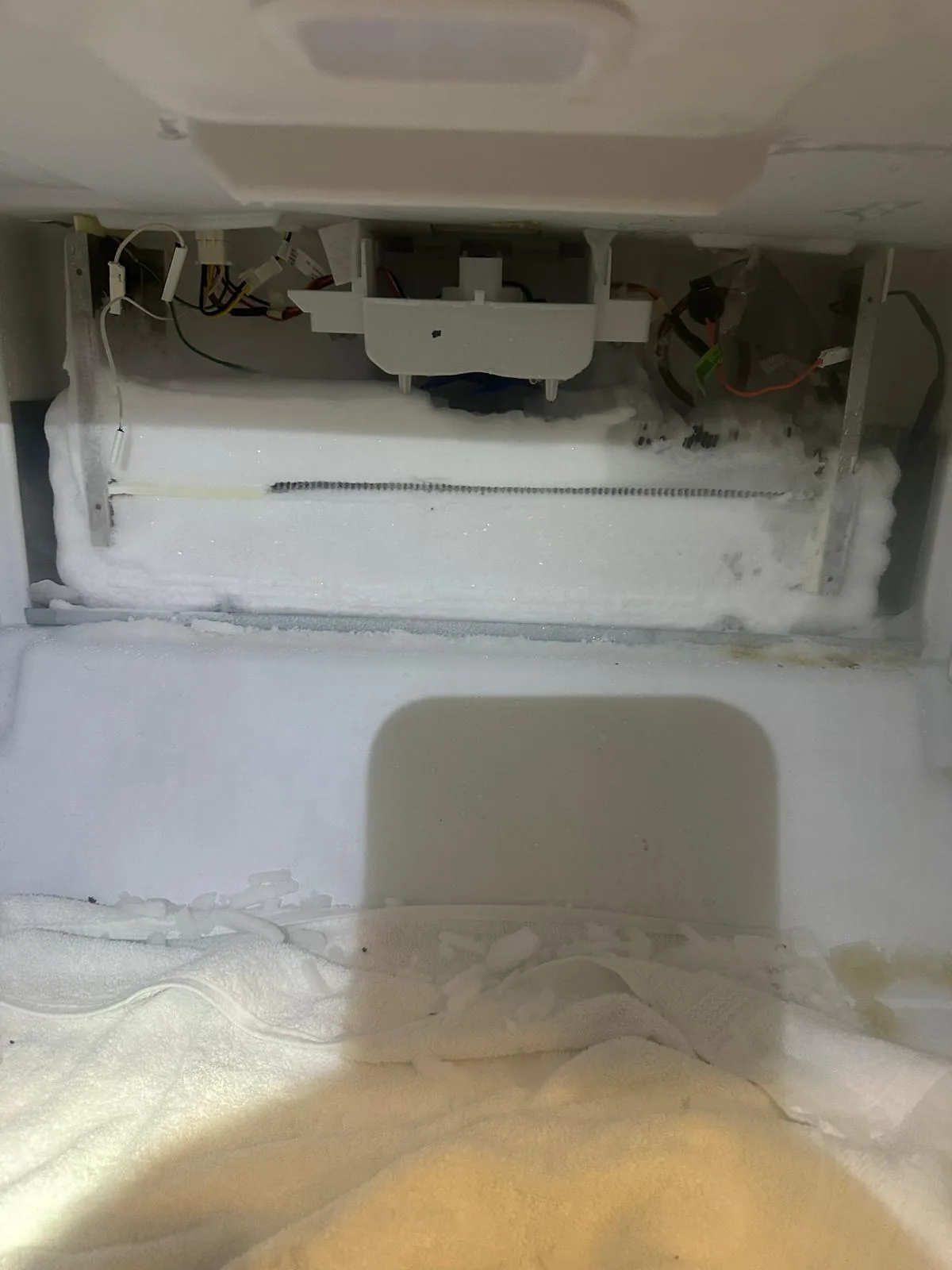 Failed evaporator fan motor being replaced in KitchenAid refrigerator