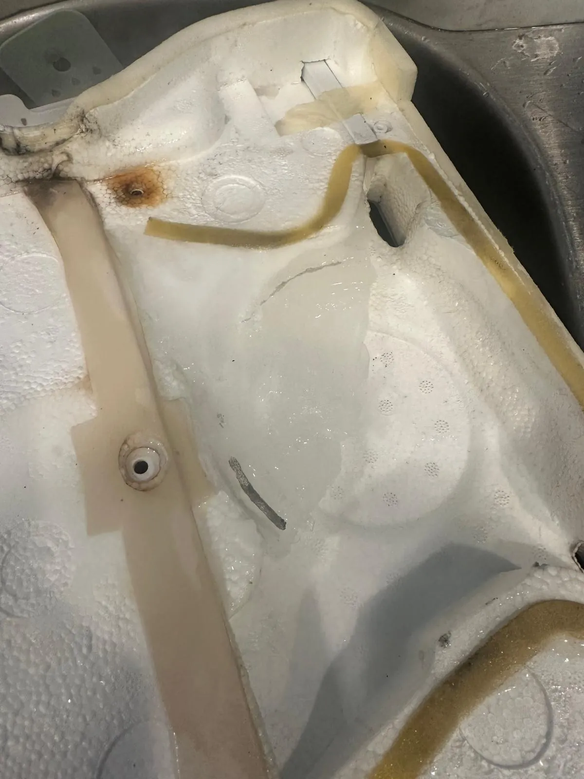 Ice buildup clogging the drain area behind the Samsung refrigerator freezer panel