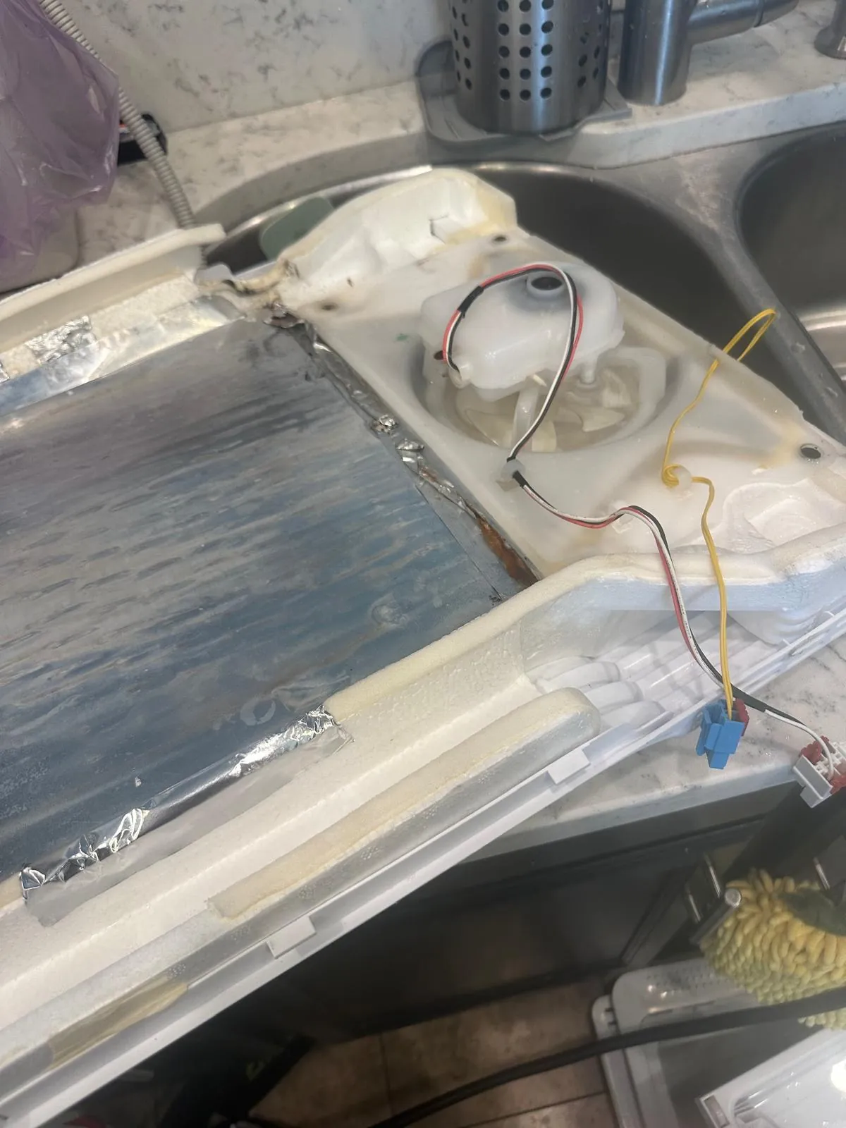 Samsung refrigerator rear freezer panel removed with evaporator fan motor housing exposed for replacement