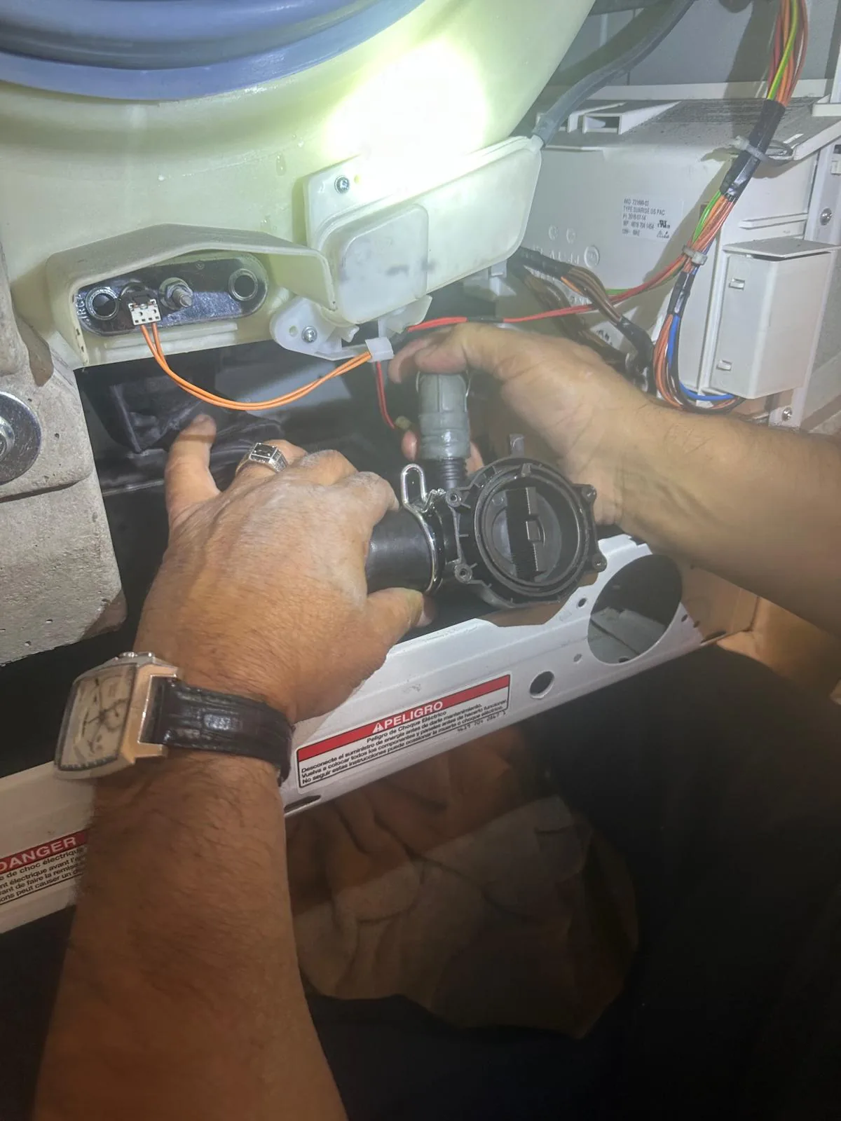 New drain pump motor being installed in Whirlpool washer